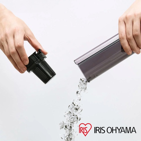 一隻手拿起黑色濾網，另一隻手傾斜著灰色集塵筒，倒出碎屑。