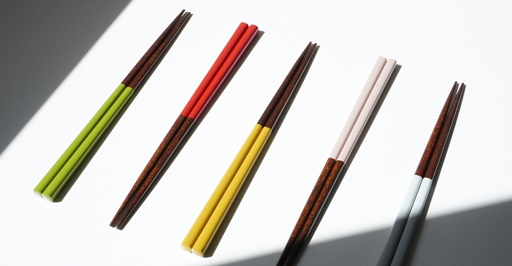 五雙木質筷子，每雙長度約23公分。筷子末端為深棕色木紋，靠近握持處則分別飾有鮮綠、紅色、黃色、粉色及淺灰色。