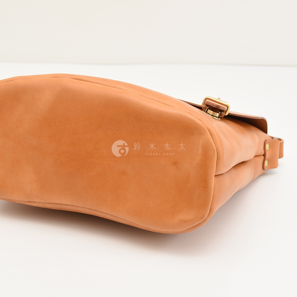 日本HERZ職人手作皮革雙扣旅行郵差包，採用品牌原創Latigo牛皮革製作，展現堅固耐用的質感，包身一側印有SUZUKI SHOP商標。