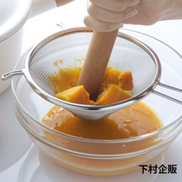 不鏽鋼濾網，網孔細密，帶有兩個金屬掛鉤，正在過濾南瓜泥。