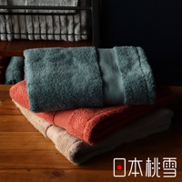 今治匹馬棉浴巾疊放，頂部為灰藍色，中層為珊瑚橘色，底部為淺褐色。浴巾質地柔軟，表面帶有細緻的絨毛。