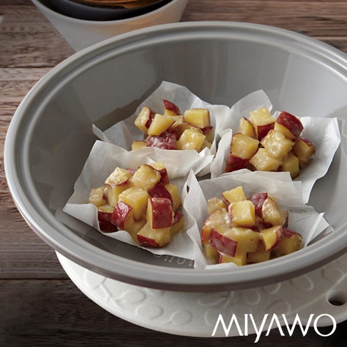 深灰色陶土蒸盤內，三份切塊的紅薯，包裹著醬汁，放在烘焙紙上。