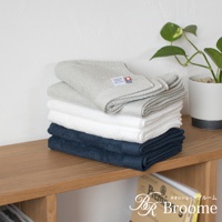 一疊今治純棉長毛巾，包含淺灰色、白色和海軍藍三種顏色。毛巾表面有菱形紋理，質感細膩，頂部淺灰色毛巾上帶有品牌標籤。