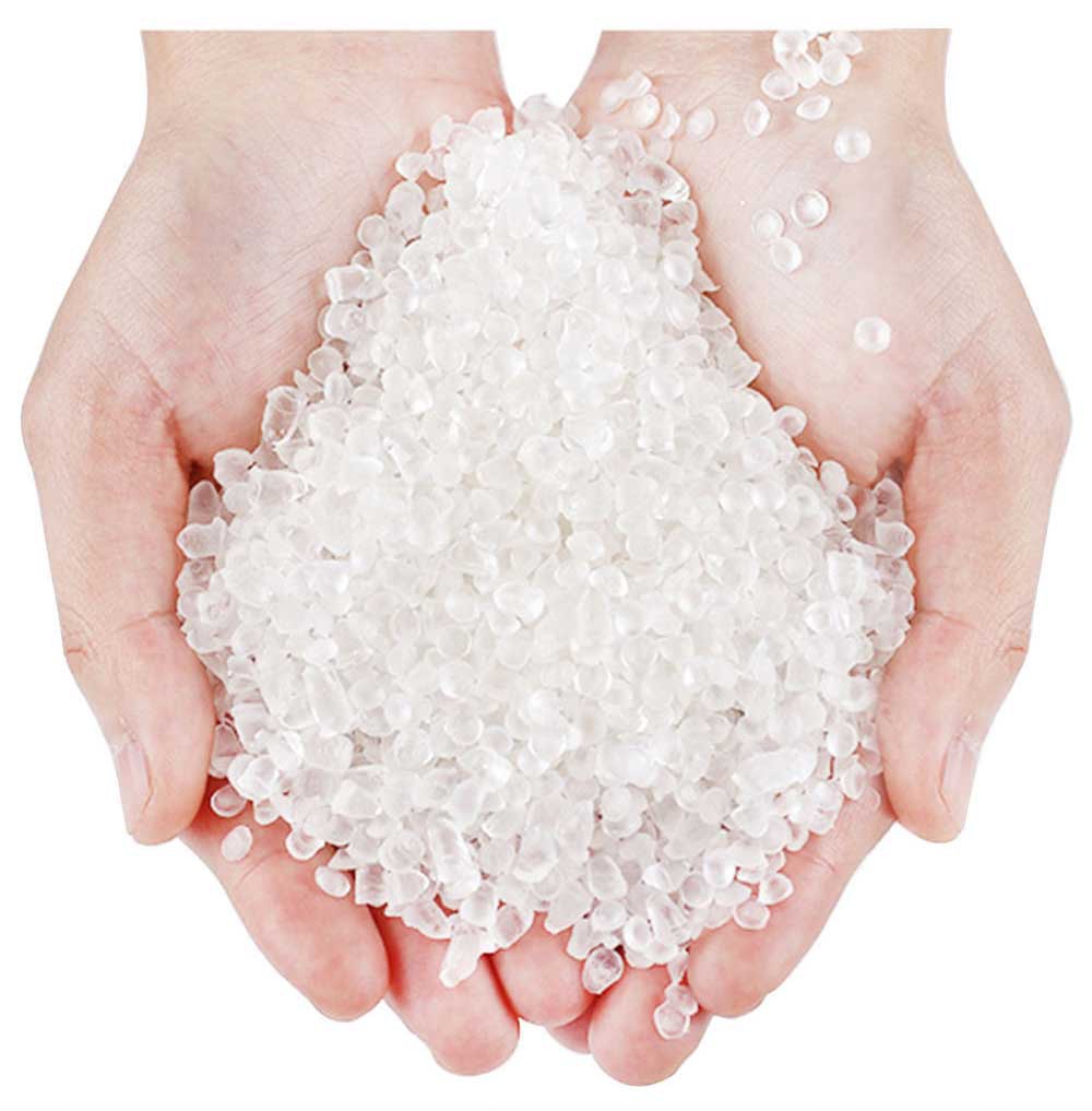 雙手捧著大量白色半透明顆粒，可能是塑膠原料，顆粒質地類似小豆子，堆積在掌中，部分掉落。