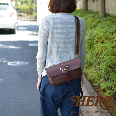 職人手作皮革單扣經典斜背包，深棕色皮革，單一主隔層，正面有皮帶扣和搭扣設計，可斜背。