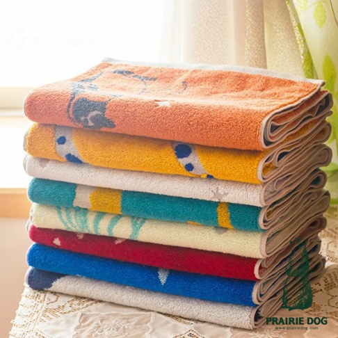 一疊今治動物刺繡雙色運動毛巾，顏色從上至下依序為橘色、黃色、白色、青綠色、米白色、紅色、藍色、灰色。毛巾表面有動物圖案刺繡，材質看起來是棉質。