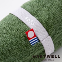 綠色毛巾纏繞著白色束帶，束帶上印有soto字樣，旁邊有一個小標籤，標籤上有紅底白圓點和藍白條紋。