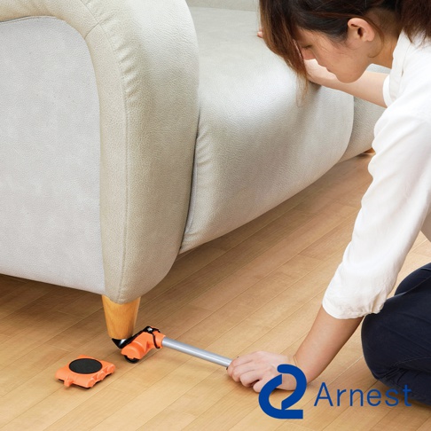 橙色圓形迷你家具起重器，帶有銀色金屬提桿，正在協助移動淺米色布藝沙發。