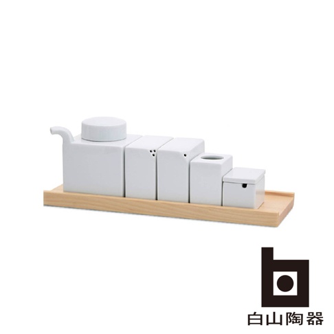 白色陶瓷調味五件組，包含一個帶有壺嘴和圓蓋的容器，以及四個方形容器，其中兩個有小孔，一個有圓形開口，一個帶有小抽屜。所有容器均放置在一個淺木盤上，呈現階梯狀排列。