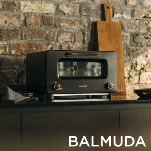 The Toaster Pro 蒸氣烤麵包機 K11C-SE 黑色，外觀為方正簡潔設計，配有銅色烤漆提把和旋鈕，機身前方有品牌 Logo、溫度與時間控制旋鈕，以及一個玻璃觀景窗。