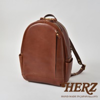 職人手作皮革多功能後背包 R-21，採用光滑棕色皮革製成，設有頂部提把、拉鍊主隔層、前置拉鍊口袋、側邊口袋及可調式肩帶。