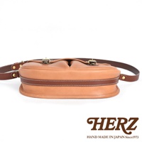 職人手作皮革傳統釣魚包，淺棕色皮革主體，深棕色皮革滾邊，縫線細緻，配有黃銅色金屬扣環與皮革背帶。