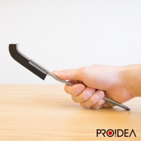 一只手握著一支 J 型隙縫刷，刷頭為黑色，刷毛密集，手柄為銀色金屬材質，呈現流線型設計。