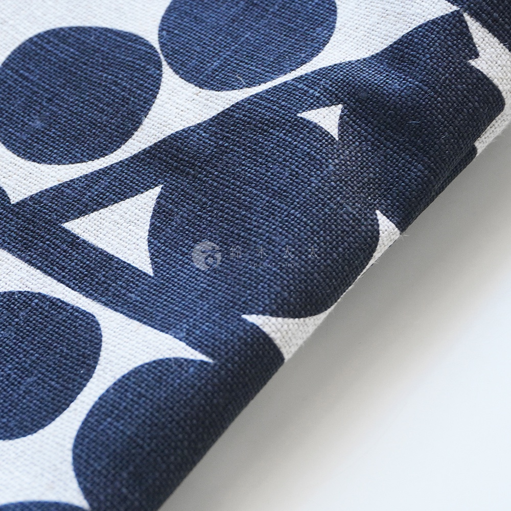 BAN INOUE 自然織紋麻布斜背包，印有藍色圓形與三角形組成的幾何圖案。