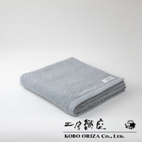 一條淺灰色、觸感柔軟的超細纖維浴巾，整齊對折，帶有品牌標籤。