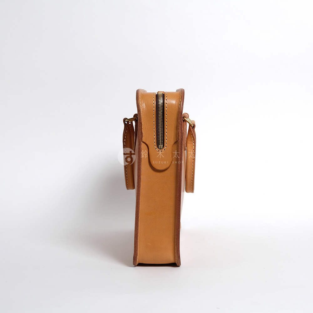 職人手作皮革手提商務公事包，採用淺棕色天然皮革，側邊展示包包的結構與銀色金屬拉鍊。