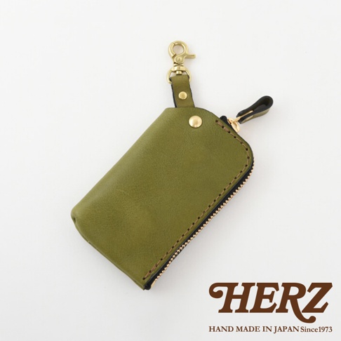 橄欖綠皮革鑰匙包，搭配黃銅扣環與拉鍊，簡約設計，可收納鑰匙。