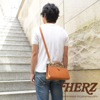 職人手作皮革復古口金兩用手提包，皮革材質，顏色為自然的棕褐色。包款設計簡潔，帶有復古金屬口金和提把，並配有可拆卸的長肩帶，可側背或手提。