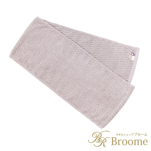Broome 品牌淺米色運動毛巾，表面織有細緻的波浪圖案，右上角有品牌標籤