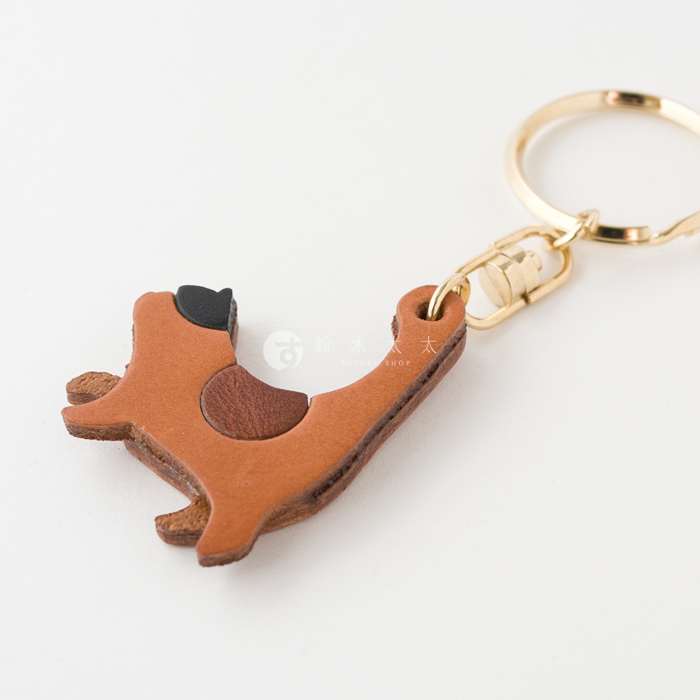 職人手作皮革貓咪造型鑰匙圈，主體為棕色皮革，貓咪臉部及身體部分點綴有深棕色及黑色皮革，搭配金色金屬鑰匙圈。