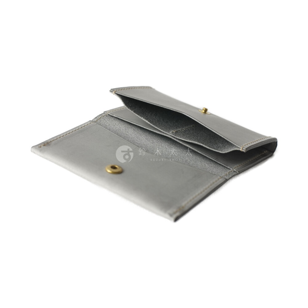 北海道KASANE 職人手作義大利Sibilla皮革卡片收納夾，灰色，特寫鏡頭，露出內側卡片夾層與金屬釦，一旁有品牌日文與英文標識