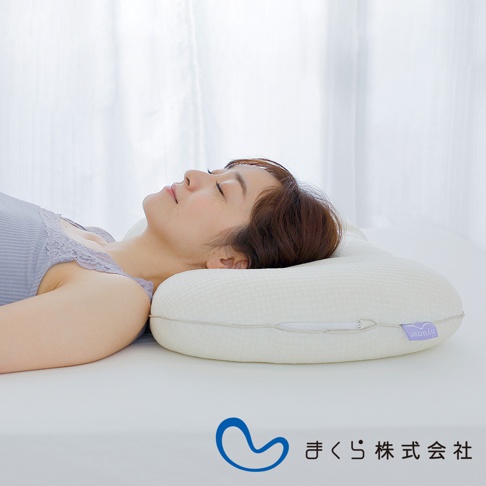 一位女性仰躺在白色床墊上，頭部倚靠著一個白色、有紋理的調節枕。枕頭有拉鍊設計，一側有紫色標籤，上面印有「hyume」字樣。