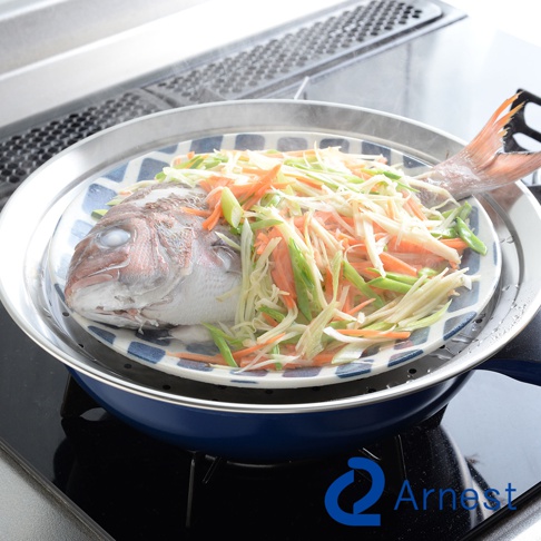 不鏽鋼蒸盤內放著一盤已切絲的紅蘿蔔、豆芽菜和青蔥，上面覆蓋著一條正在蒸煮的魚。