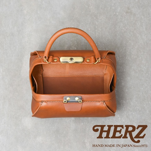職人手作皮革Organ兩用口金手提包，呈經典醫生包造型，材質為棕色皮革，配有黃銅色金屬口金與扣環，頂部有提把。