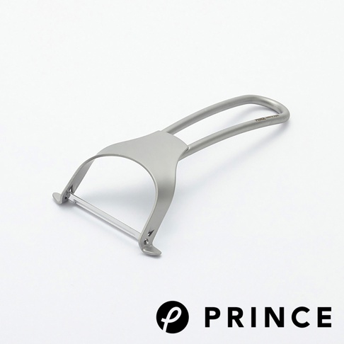 銀灰色金屬削皮器，具有彎曲的握把和刀片，刀片部分嵌在金屬支架中，整體設計簡潔。