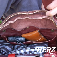 職人手作皮革水洗加工迷你波士頓包，內裡為紅棕色皮革，可見手機、耳機及一條格紋布料。