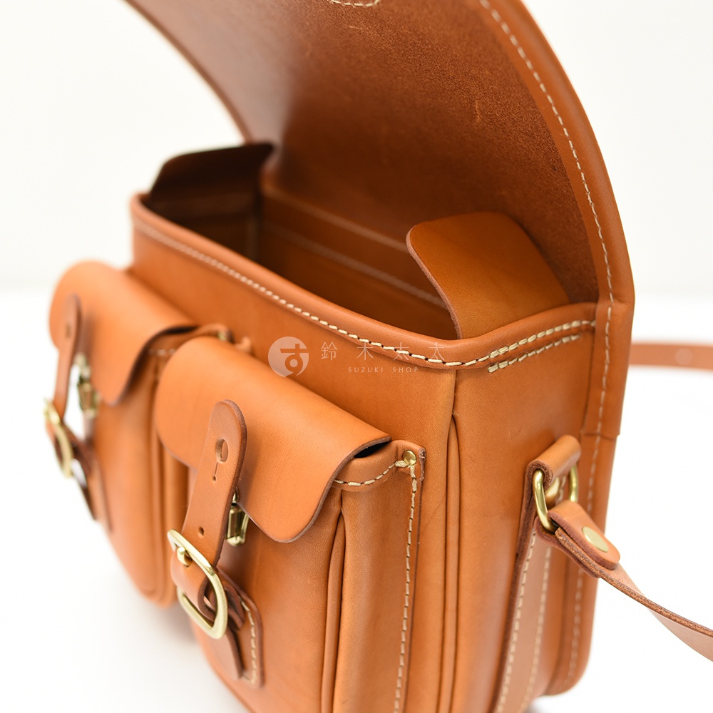 日本HERZ職人手作皮革經典雙扣郵差包，特寫視角展示包包的縫線細節與銅釦，以及內袋的結構。