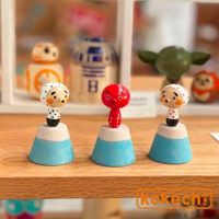 三款木芥子開運擺飾，分別為紅色章魚造型與兩款白色頭巾、圓點圖案人偶，皆立於藍白相間的富士山造型木座上。