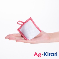 手掌上托著一個白色網狀材質、邊緣為紅色格紋的方形洗衣槽去污包，上方有紅色格紋提帶。