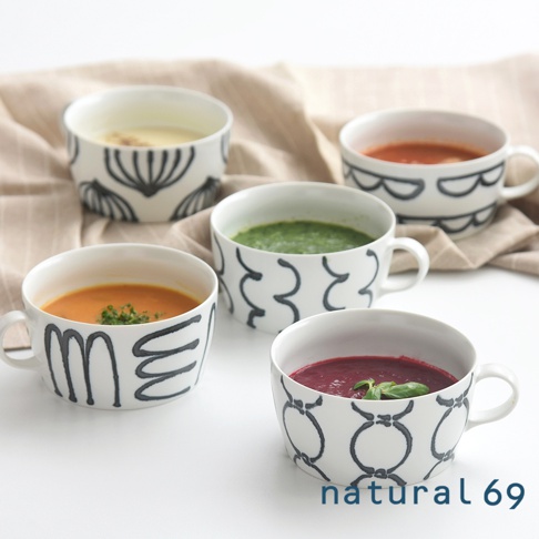 五個附耳的白色陶瓷湯杯，分別盛有黃色、橘色、綠色、紅色和紫色湯品，杯身皆以黑色手繪線條裝飾，風格簡約。