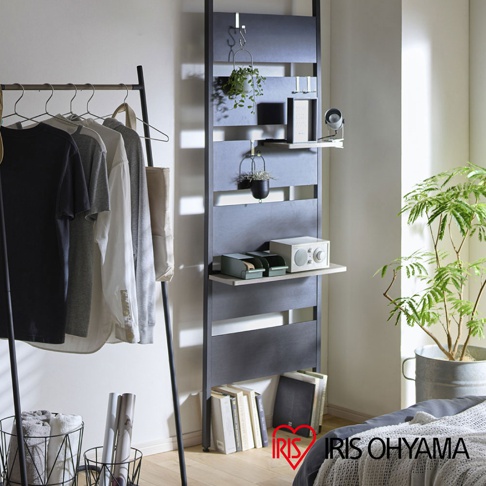 頂天立地木質收納架，深灰色木質框架，附有數個淺木色層板，上面擺放著綠植、音響、收納盒和書籍。