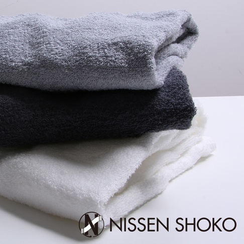 一疊三色（淺灰、深灰、白色）的長毛巾，材質為柔軟的毛圈織物，呈現蓬鬆質感。