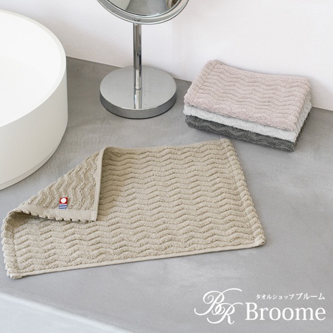 Broome 品牌 ASH 系列今治柔韻波紋甘撚手帕，淡米色，質感緹花織法呈現細緻波浪圖案，左側有品牌小標籤。