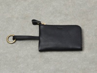 黑色皮革鑰匙包，附有金色拉鍊、皮革拉環和金色掛環，包身呈現粒面紋理。