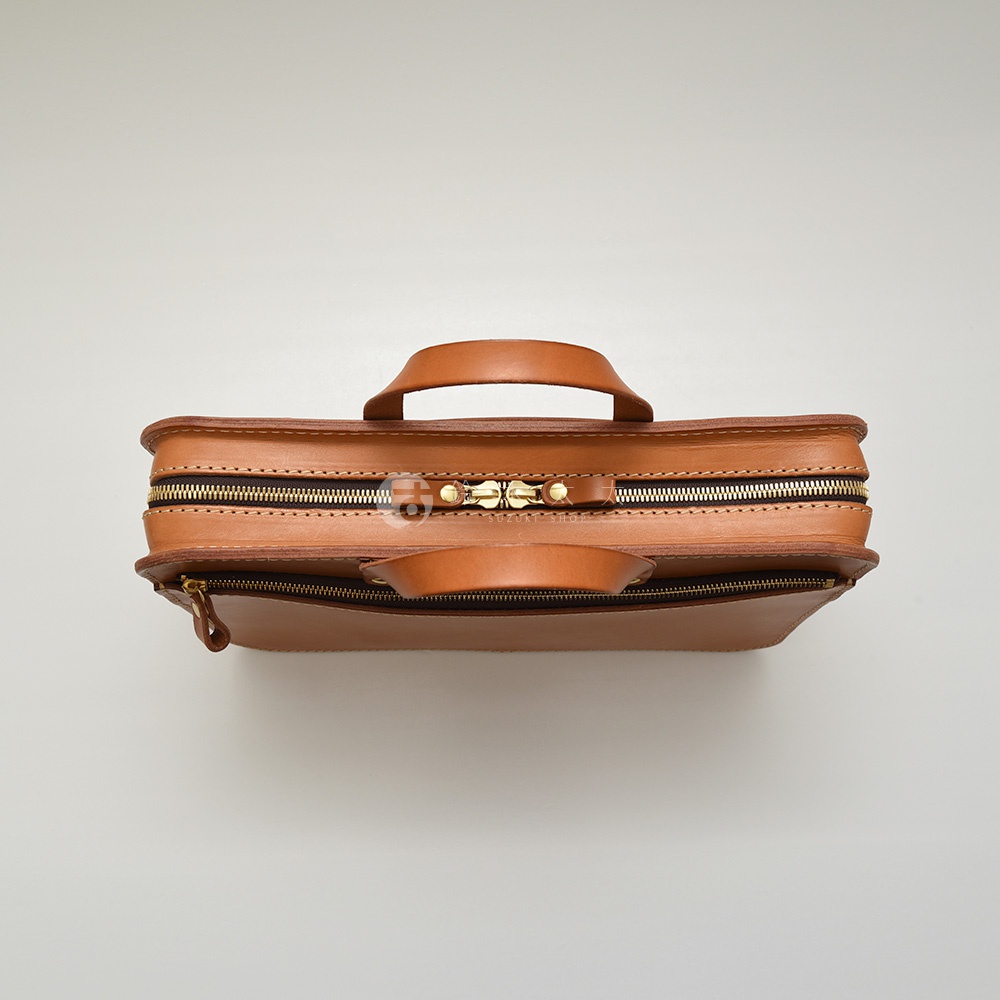 職人手作皮革兩用商務公事包 BW-110，採用天然棕色皮革，配有黃銅色拉鍊，頂部設有提把，正面有一個拉鍊隔層。