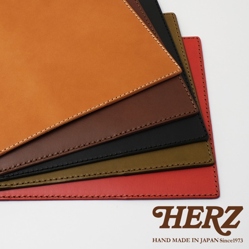 職人手作皮革B6記事本書套，展示了焦糖色、深棕色、黑色、軍綠色和紅色五種顏色，均以白色縫線裝飾，皮革材質。