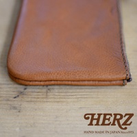 職人手作皮革Organ拉鍊式小物收納袋，採用棕色皮革製作，拉鍊處縫線細緻，質樸的皮革紋理清晰可見，整體呈現溫潤的質感。