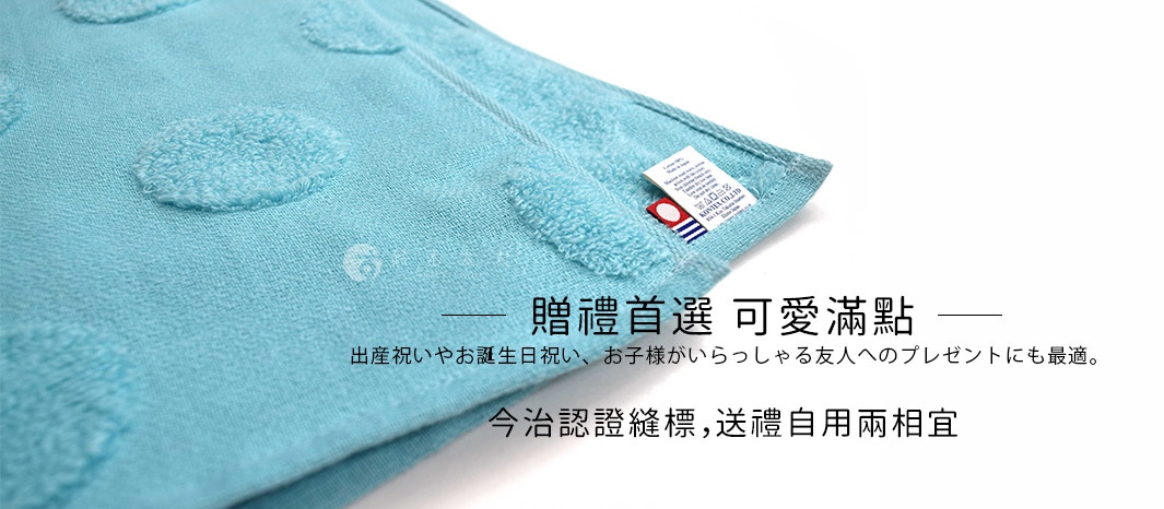 淺藍色紗布材質浴巾，表面有立體圓點紋路。角落處可見品牌標籤，整體為嬰幼兒禮盒的一部分。