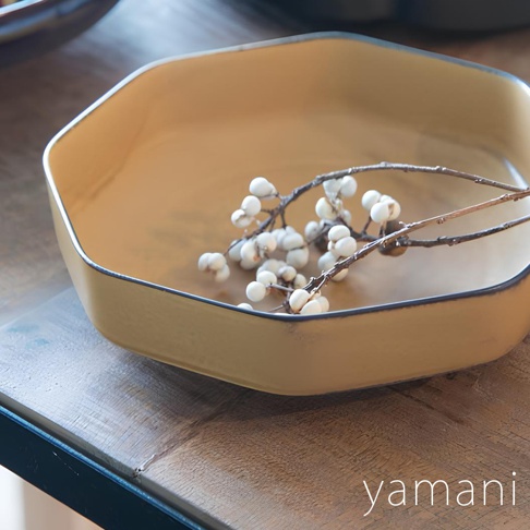 芥黃釉美濃燒八角盤，盤面呈芥黃色，邊緣有一圈深色線條。盤內放置著一枝帶有白色漿果的乾燥樹枝。