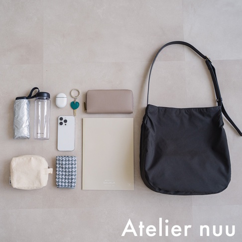 Atelier nuu ssent 肩背托特包，內含化妝包、手機、鑰匙、錢包、筆記本、水壺和雨傘，皆呈現在淺色背景上