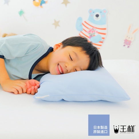 淺藍色軟綿綿的枕頭，上面躺著一位閉眼微笑的男孩，男孩身穿淺藍色帶深藍色滾邊的短袖上衣。