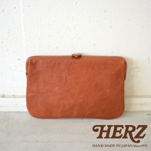 棕色皮革職人手作Organ手拿包，方形包身，頂部中央有一個金屬按扣，側面有拉鍊。