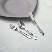 Flora系列不鏽鋼點心叉匙刀三件組，精緻的餐具組合，包括一把叉子、一把湯匙和一把奶油刀，皆由高品質不鏽鋼製成，閃耀著迷人的金屬光澤，優雅地擺放在淺灰色的盤子旁，營造出精緻的用餐氛圍。