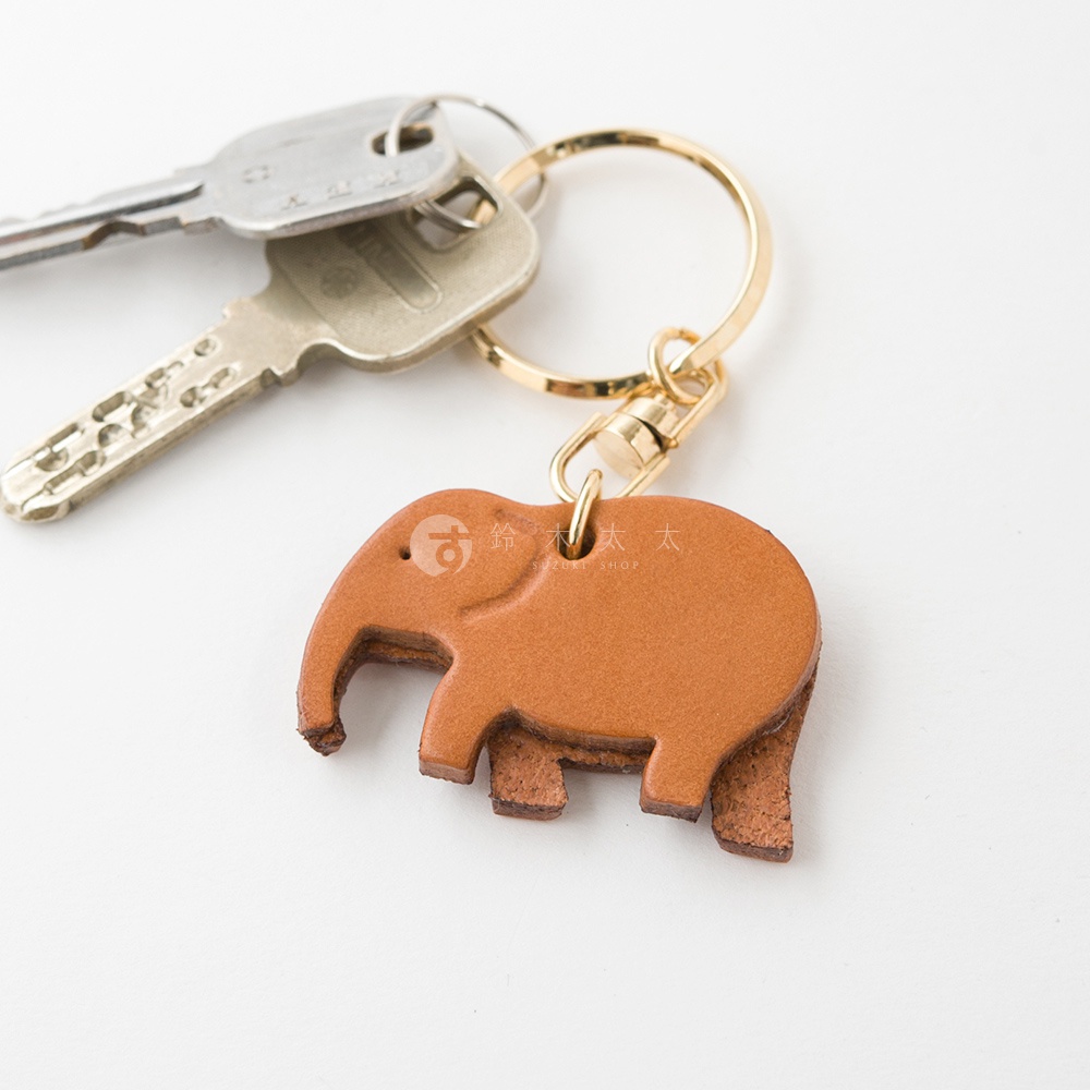 職人手作皮革大象造型鑰匙圈，咖啡色皮革，搭配金色金屬掛環與鑰匙。
