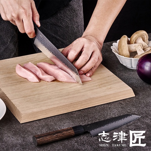 志津匠玄 Bunka 文化刀，正在切雞胸肉，一旁有香菇和茄子，另一把同品牌刀具放在桌面。