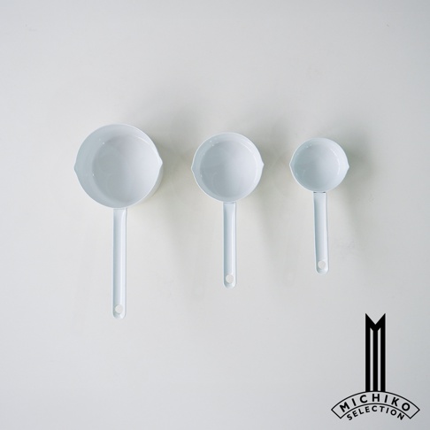 三個不同大小的白色琺瑯量杯，由左至右尺寸遞減，上方有品牌logo。